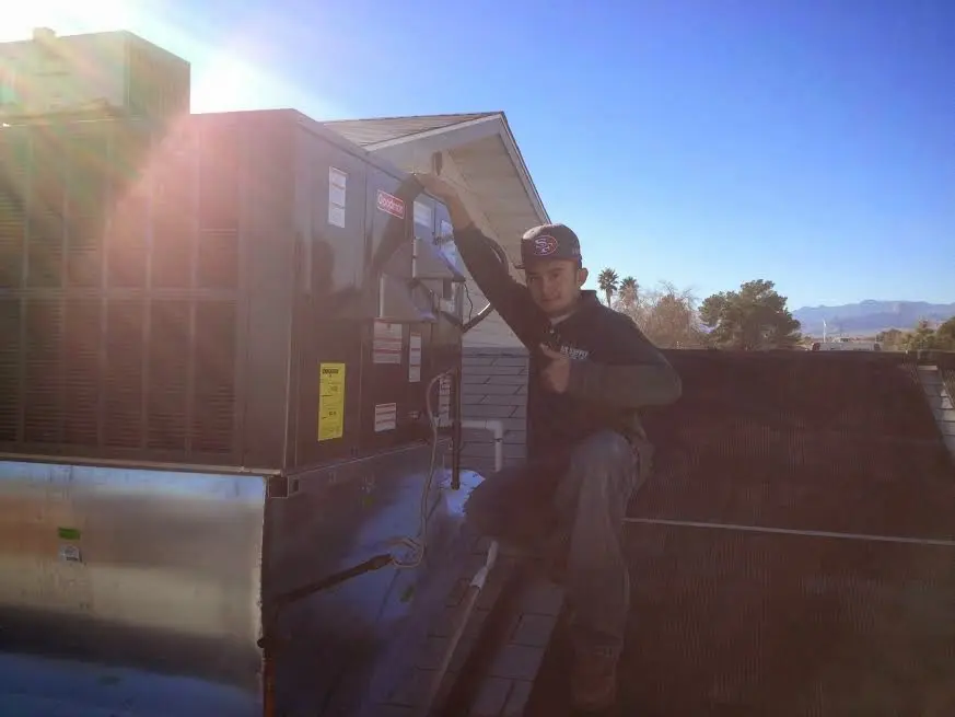 HVAC technician performing AC Tune-Up on a rooftop unit in Sayre